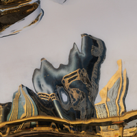reflection pictures of towers and the street on the steel statue 